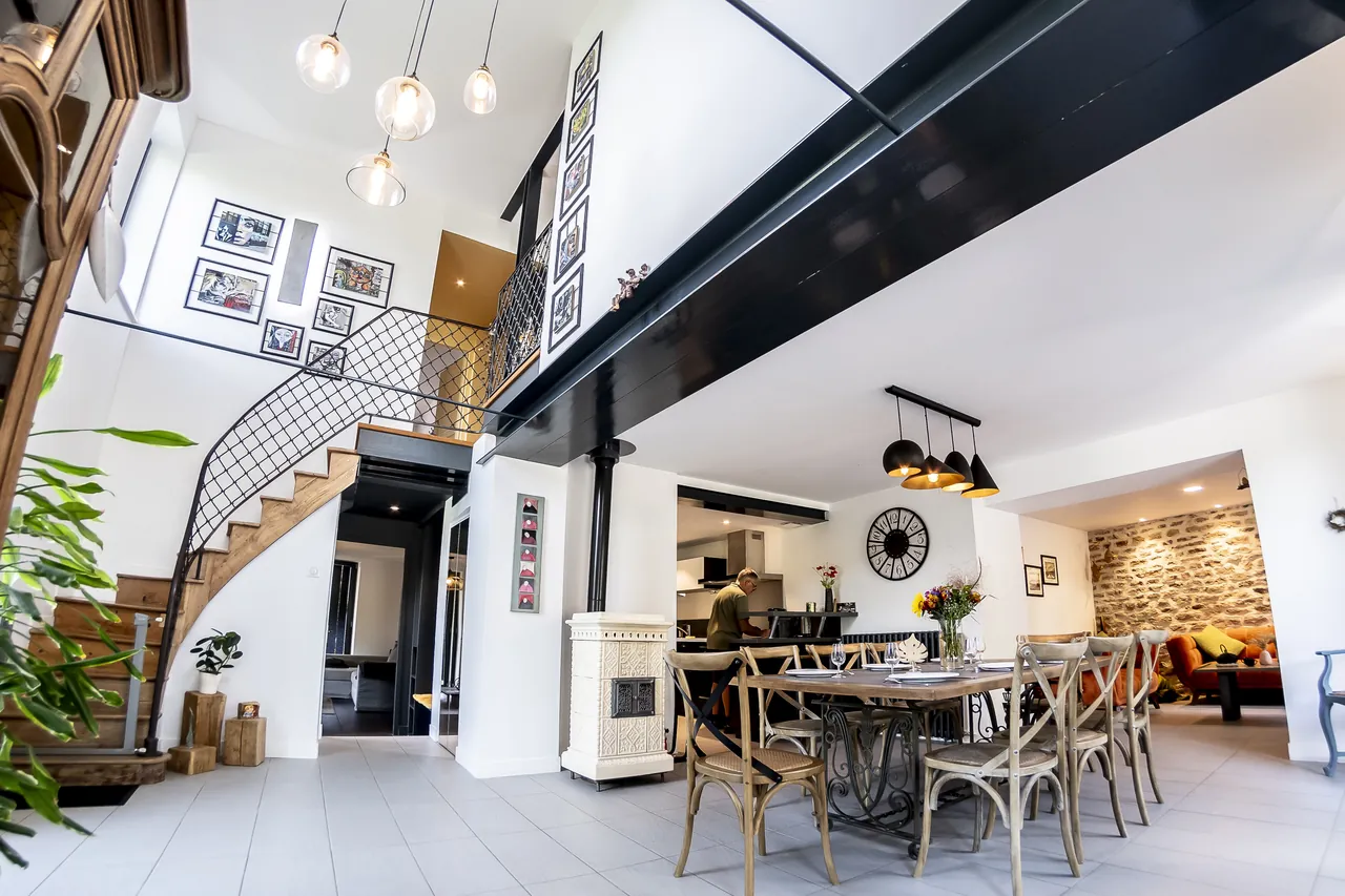 La pièce à vivre en double hauteur, sa mezzanine et la salle à manger